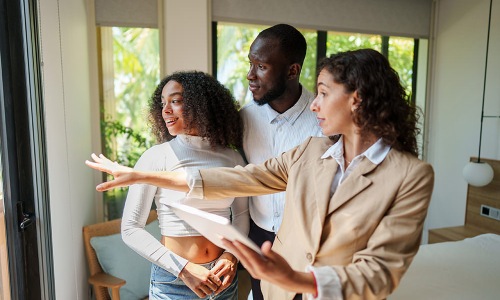 agent showing couple around an apartment